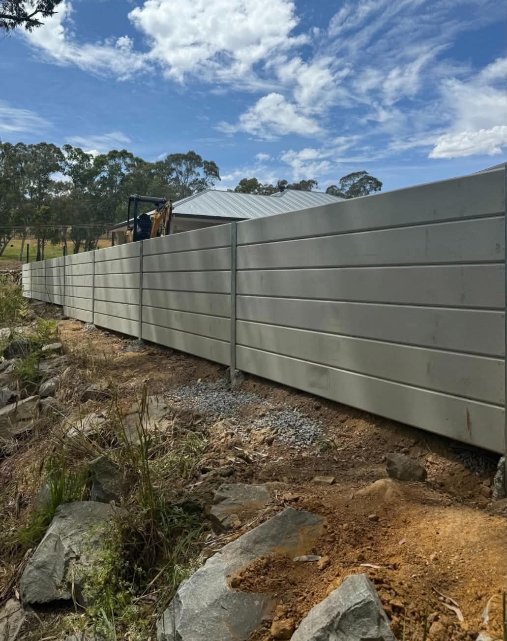 Treated pine sleeper retaining wall built under a Colorbond fence line in Penrith